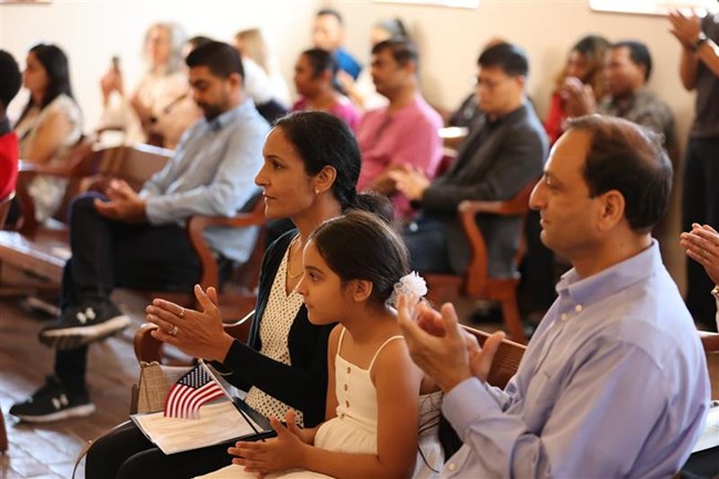 Family of three sits during Naturalization Ceremony