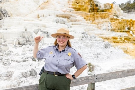 a park ranger in front of a thermal feature