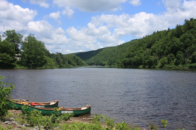 Park Ranger canoes on the shore of the Delaware River.