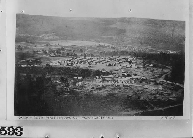 Distant photo of a hilltop, military encampment partially visible