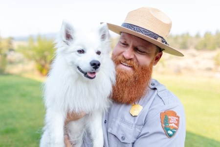 a park ranger holding a dog