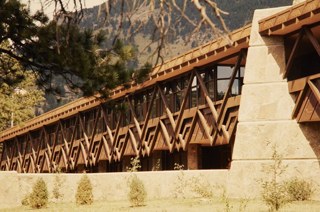 Beaver Meadows Visitor Center The front of a wide, low building showing a repeating geometric pattern made of wood beams