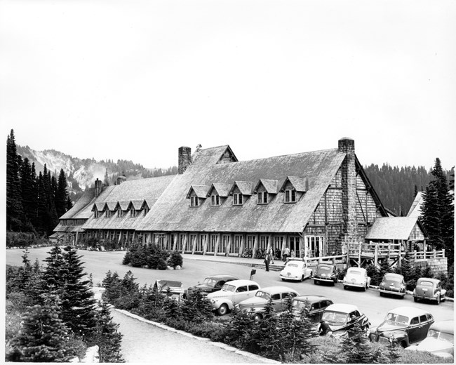 A large A-frame style building with many dormers and two chimneys