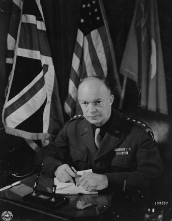 A black and white image of a man in a military uniform sitting at a desk