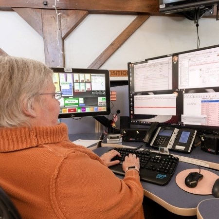 Emergency Dispatching a woman sitting at a desk with multiple computer monitors