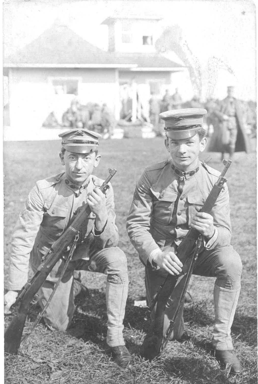 Soldiers at Fort Hancock Two young soldiers kneel in their uniforms holding guns