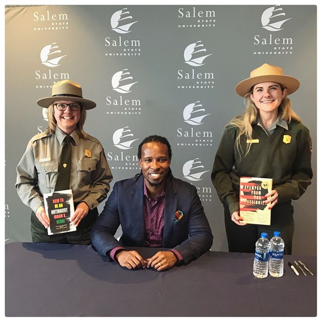 Two park rangers and an author at a book signing