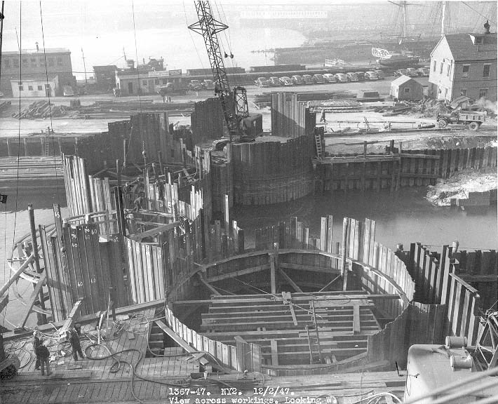 a cofferdam, made up of four large circular structures, on the edge of the dry dock currently filled with water