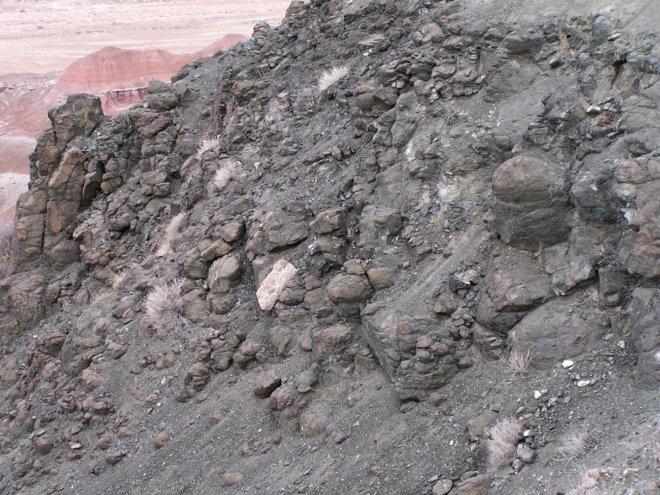 photo of dry dusty hillslope with rounded pillow basalts exposed