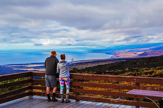lt= Visitors enjoying a view of the coastline from an overlook.