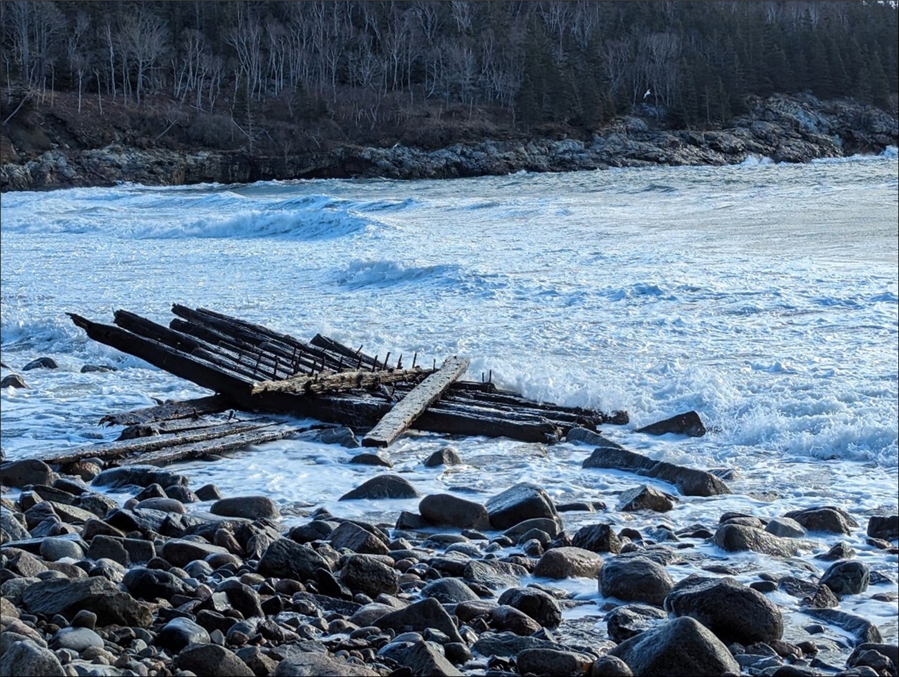 Boards in the water with a rocky shore Boards in the water with a rocky shore