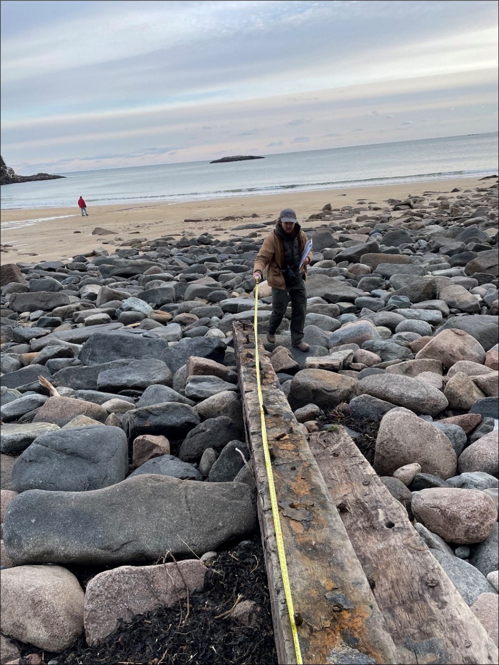 Person uses measuring tape on a length of wood Person uses measuring tape on a length of wood