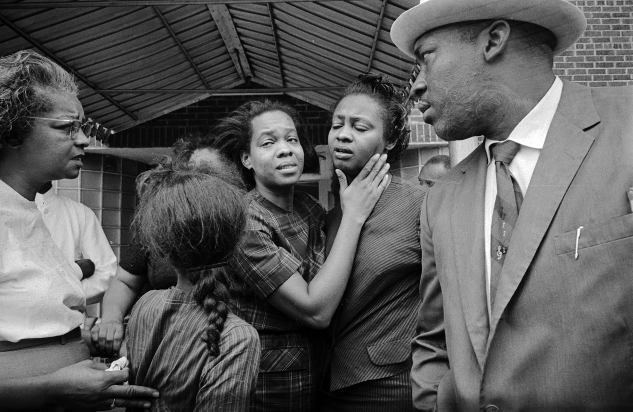 Juanita Jones hugging her sister, Maxine McNair (mother of bombing victim Denise McNair), in front of Social Cleaners across the street from 16th Street Baptist Church, after the building was bombed. Juanita Jones hugging her sister, Maxine McNair (mother of bombing victim Denise McNair), in front of Social Cleaners across the street from 16th Street Baptist Church, after the building was bombed.