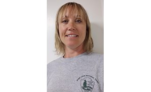 Smiling woman with blonde hair and a gray t-shirt.