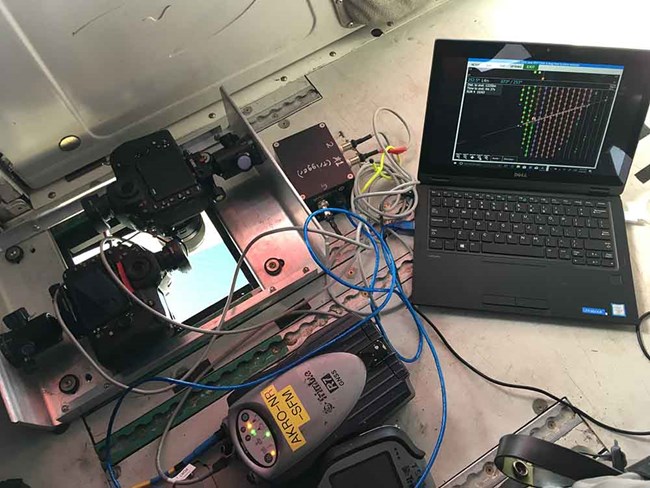 AKRO SfM System Installed_2018_08_30_web A computer and camera set up in the belly port of a plane.