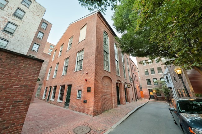 Brick building with tall arched windows on the second level.