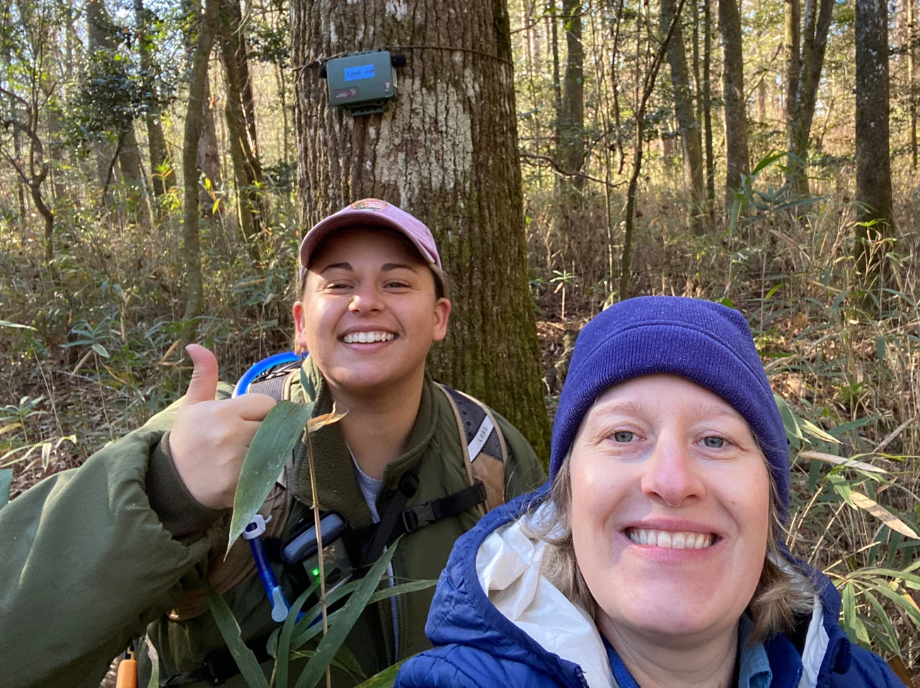 Putting out ARDs Two people smiling for a selfie in the woods
