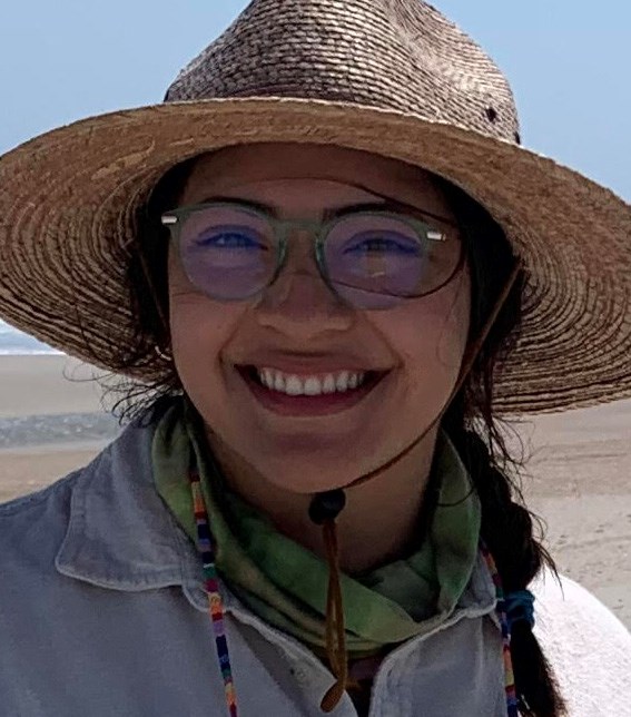 Abby Gonzalez woman in a hat smiling and wearing glasses