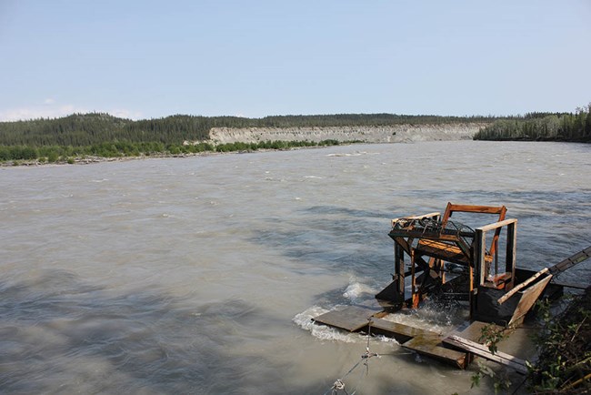 A wide river with a fishwheel along one bank.