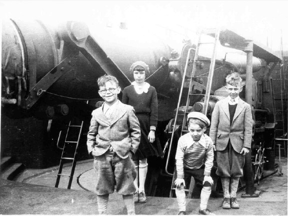 four young children pose in front of disappearing gun