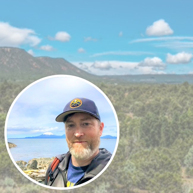 Erik and Glorieta Pass Battlefield NHL, part of Pecos National Historical Park Circular inset of bearded man in baseball cap sits on landscape photo of southwest landscape with mesa flattop mountains and blue skies.