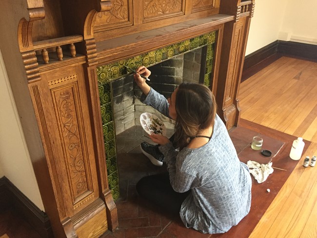 Alex Beard inpainting glazed fireplace tiles at the Eustis Estate. Alex Beard inpainting glazed fireplace tiles at the Eustis Estate.