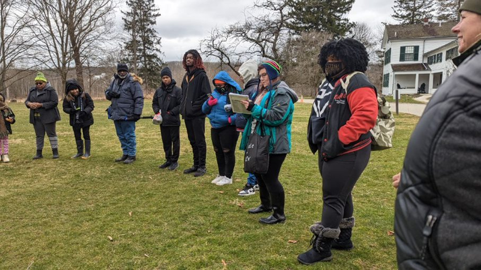 A group of people standing in a circle outside.