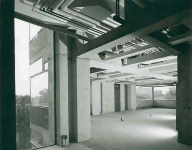 Archival Construction photo showing original piping, ductwork, and fixtures.