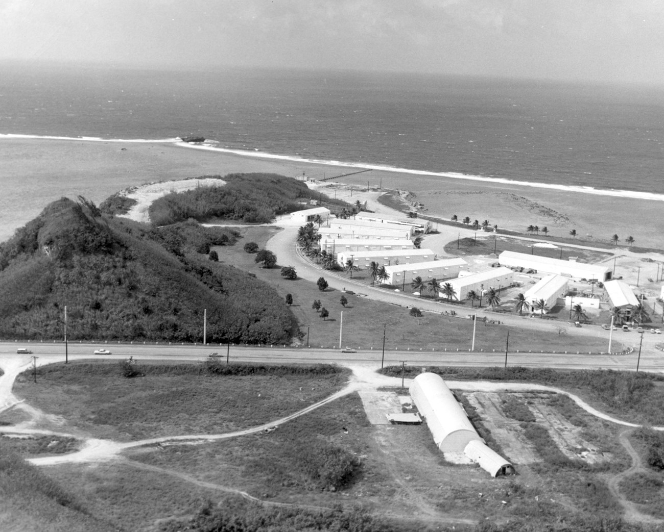 A collection of large white buildings arranged in a semi-circle next to the ocean.