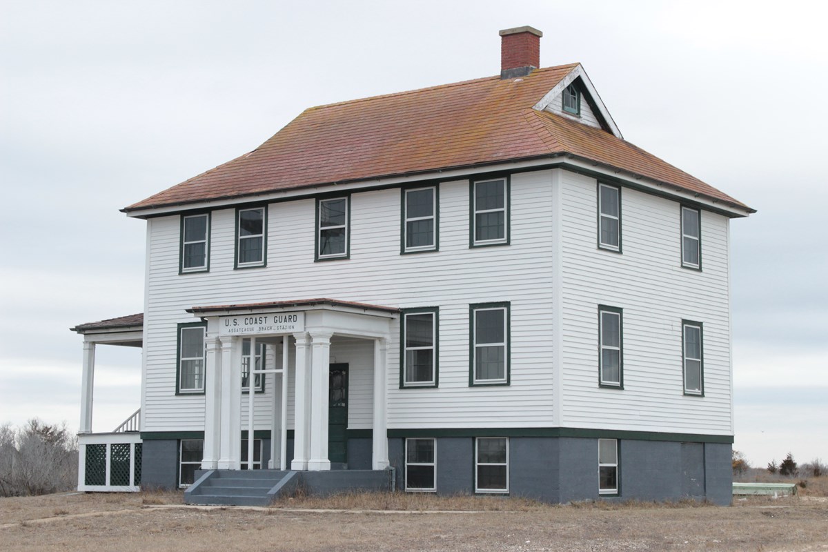 Large two-story white house on a marsh