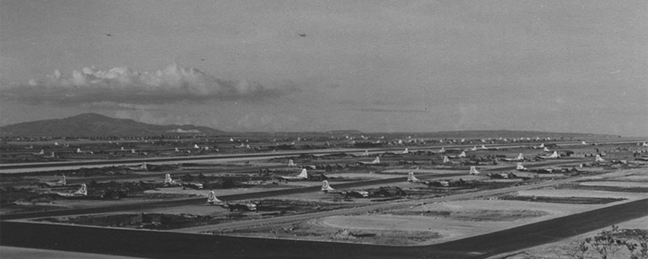 Black and white photo of Tinian airfield with several B-29s parked.