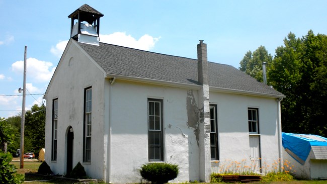 Small white church building.