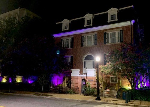 BEPA lit up in purple and gold for Forward Into Light Aug 26 2020 NPS photo Exterior of Belmont Paul with purple and gold lights for 19th Amendment Centennial