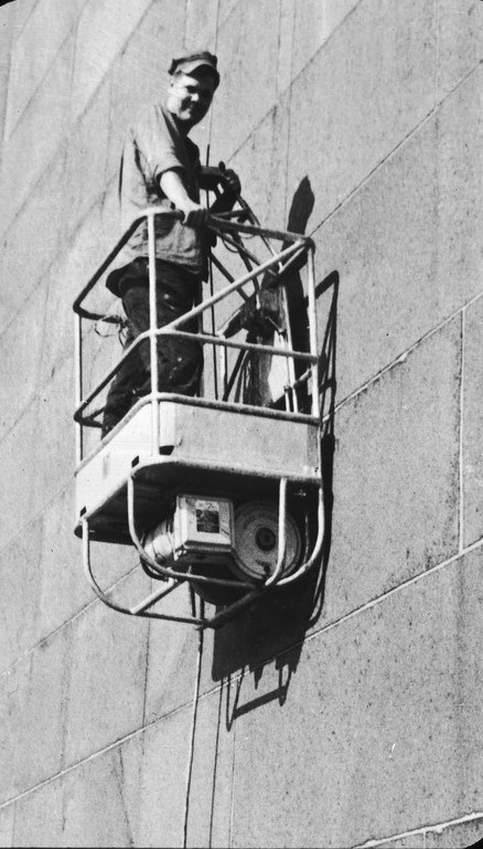 A worker in a cable car platform that hugs the side of the Bunker Hill Monument.