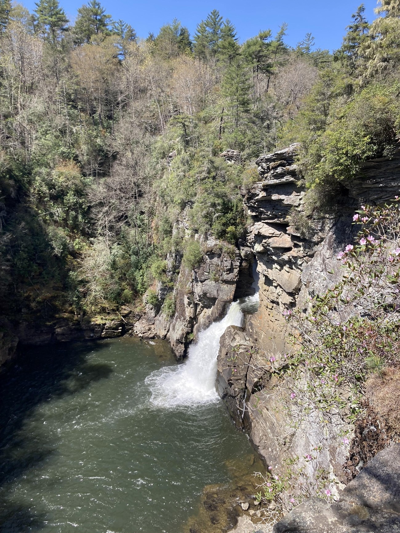 Linville Falls, Blue Ridge Parkway a waterfall flowing into a large basin with trees surrounding