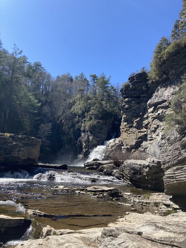 a lower angle of the waterfall, showing shallow water and rocks