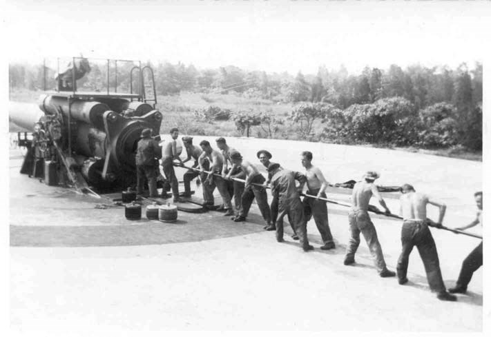 a group of soldiers insert a ramrod into a gun