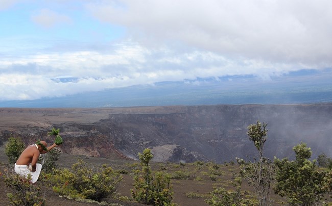 lt= A man leaving an offering at the rim of a crater.