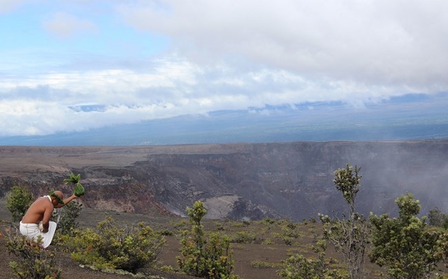 A man leaving an offering at the rim of a crater.