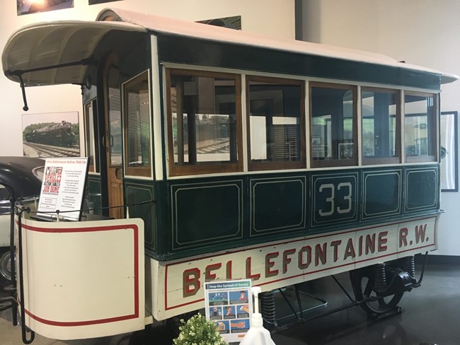 Green, red, and cream railway car with text that reads "33 Bellefontaine R.W."