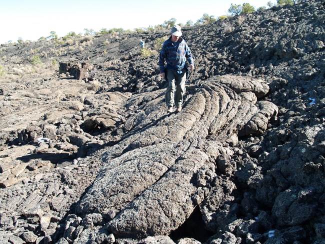 a person walking on an area of ropy lava