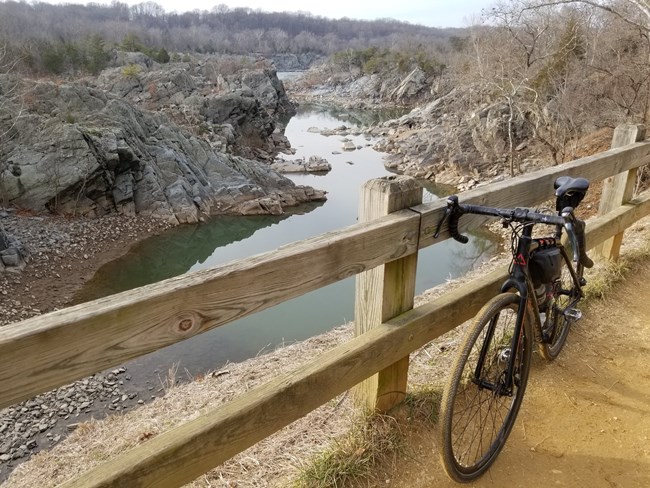 Biking in Great Falls Bike resting on a wooden fence with the Potomac River crashing in the background.