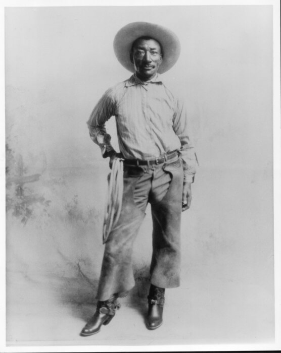 Man standing with cowboy clothes.