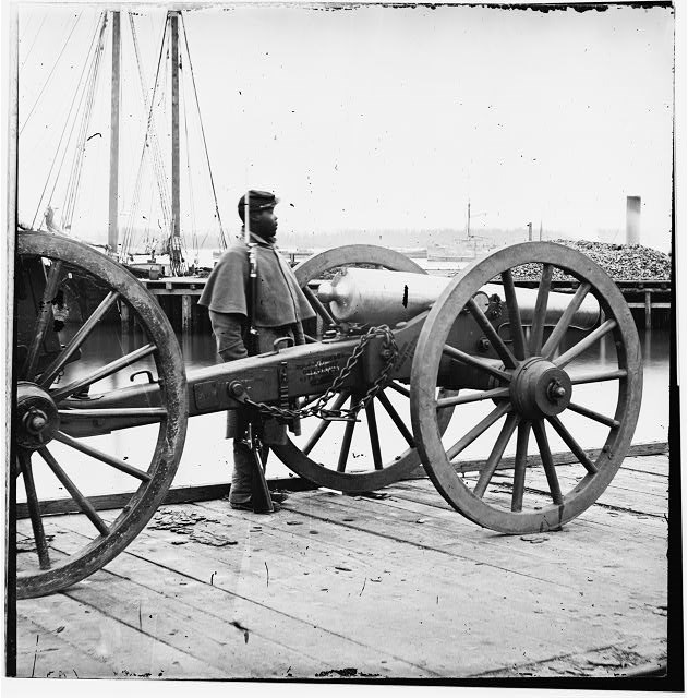Black Civil War Soldier Standing Guard Black Civil War soldier standing guard, a cannon is positioned in front of him.