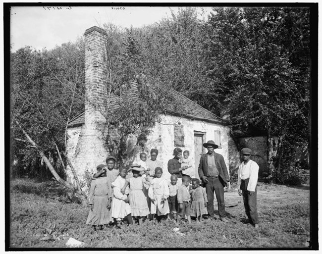 large African American family posing in front of house