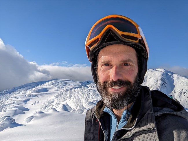 A man stands on a snow-covered mountain.