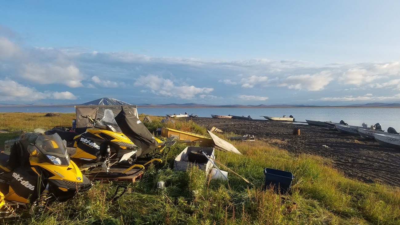 Snow machines and boats, key resources for subsistence harvest practices, await use on the Arctic coast.