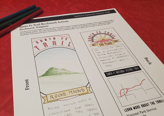Bookmark worksheet and colored pencils on a red table