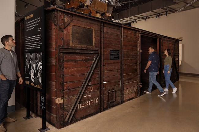 Museum visitors explore a boxcar on display People explore a boxcar on display