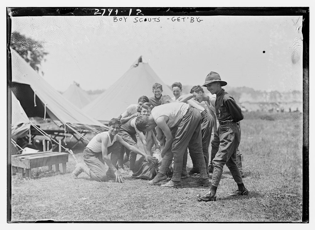 lt= Young teenage boys playing outside of tents